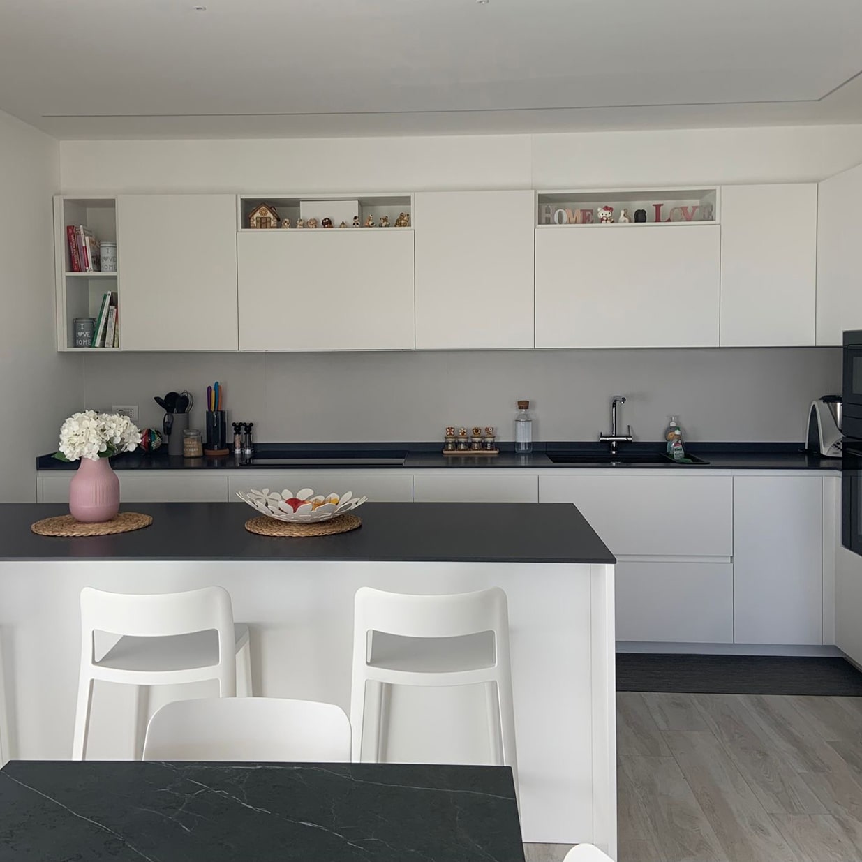 cucina moderna bianca e nera con sgabelli alti